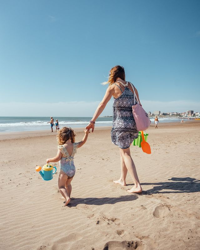 Madre e hija caminando por la playa de Mar del Plata